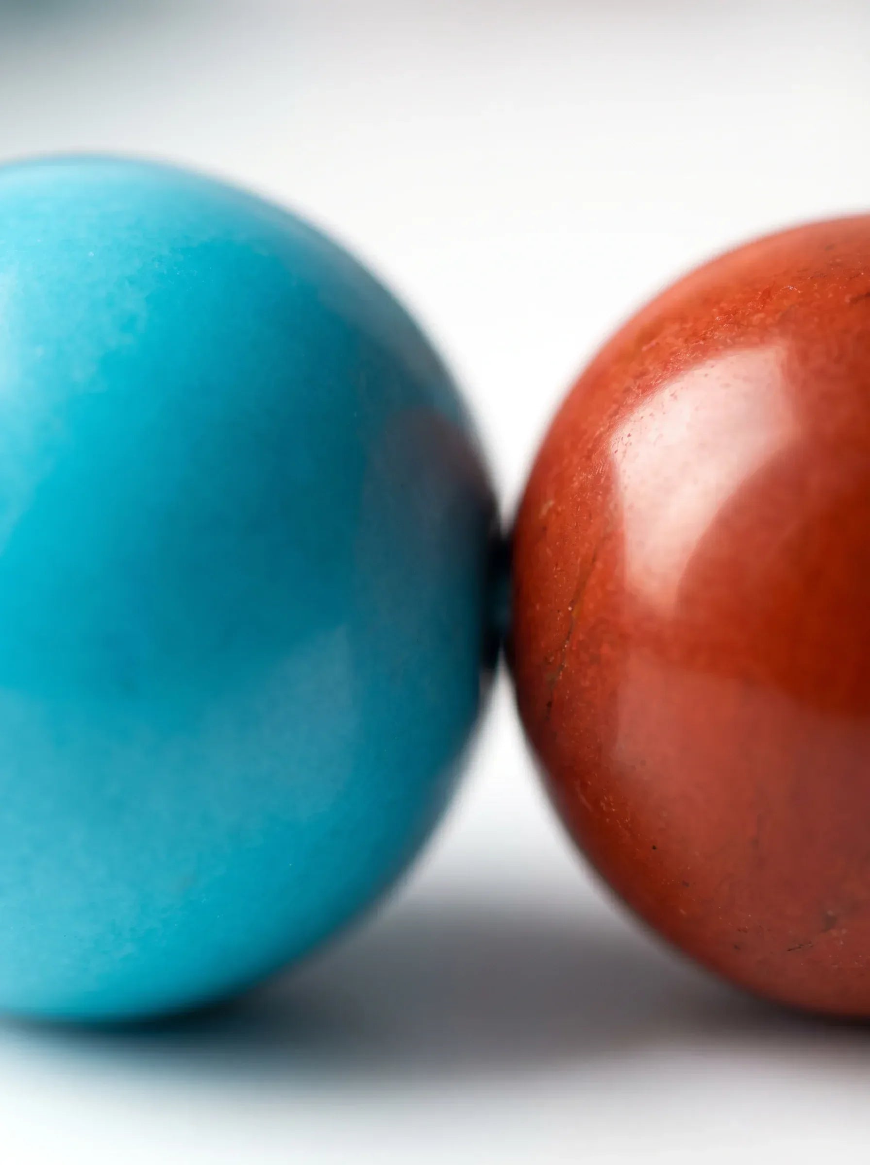 OresGreen Ember Bracelet macro details: Ultra-close up shot showing a flawless natural blue turquoise bead touching a polished red agate gemstone sphere, highlighting genuine minerals and exquisite hand-selected stone quality.