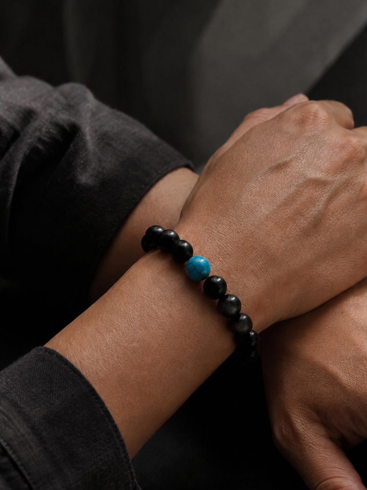 Wrist wearing Obsidian Focus Bracelet, showing the smooth texture and classic silhouette. Its timeless design ensures it stays a staple in your jewelry collection for years.