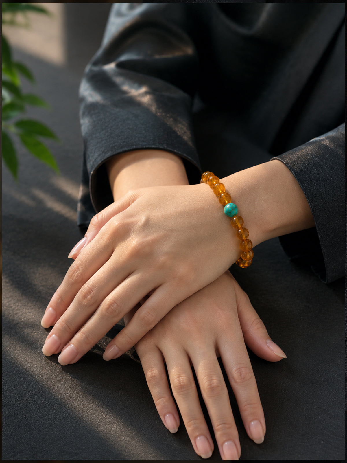 On-wrist view showing how the organic amber beads reflect light, capturing the soft warm glow of the bracelet.