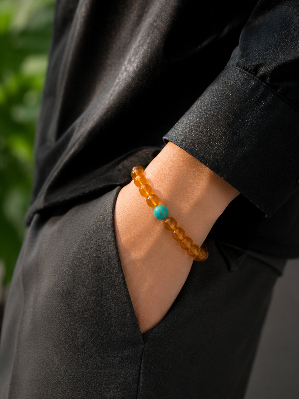 Elegant hand model presentation showcasing the flexibility and premium quality of the OresGreen Amber Glow Bracelet.
