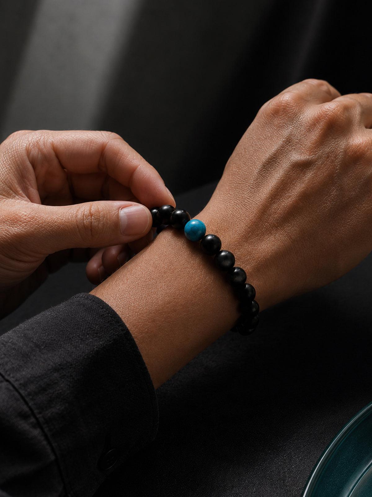 Close-up of Obsidian Focus Bracelet on wrist, polished natural black obsidian beads and subtle accents. Its timeless design ensures it stays a staple in your jewelry collection for years.