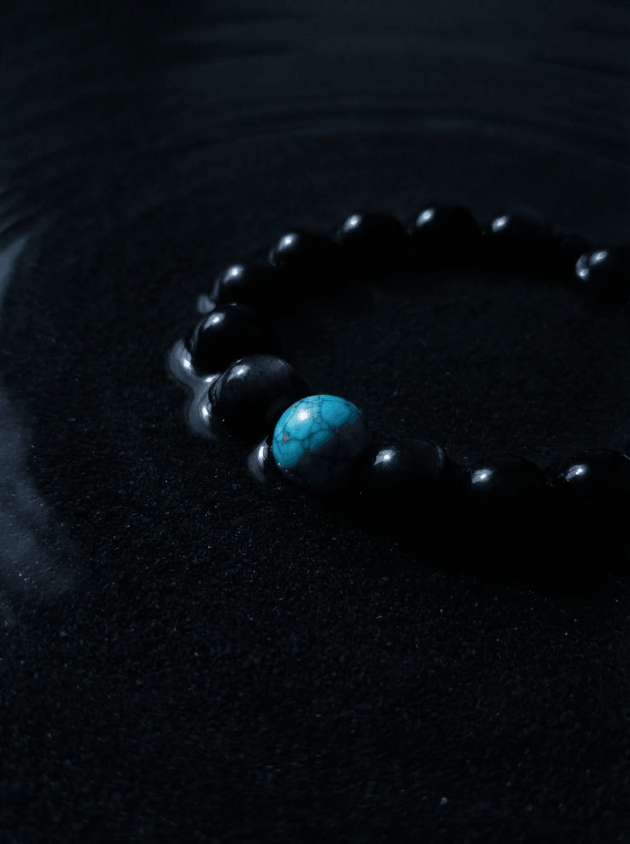Handcrafted natural black obsidian crystal and real turquoise gemstone bead stretch bracelet by OresGreen, styled on a dark slate background for spiritual grounding, mindfulness, and protection.